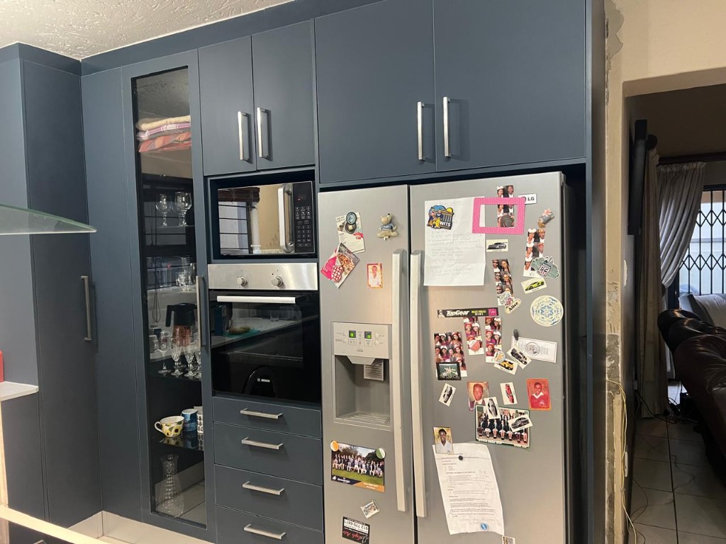 Custom kitchen installation with charcoal cabinets and white countertops