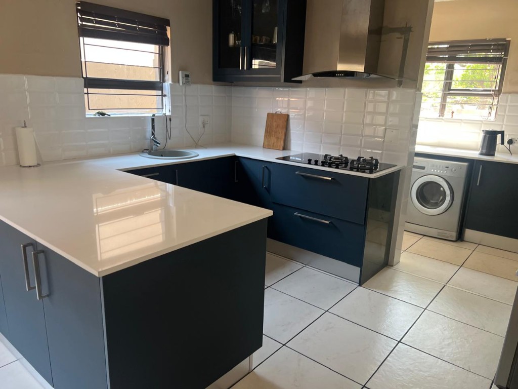 Kitchen with glass-front upper cabinet and stainless range hood