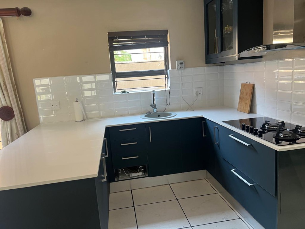 Wide view of charcoal and white kitchen with integrated laundry zone