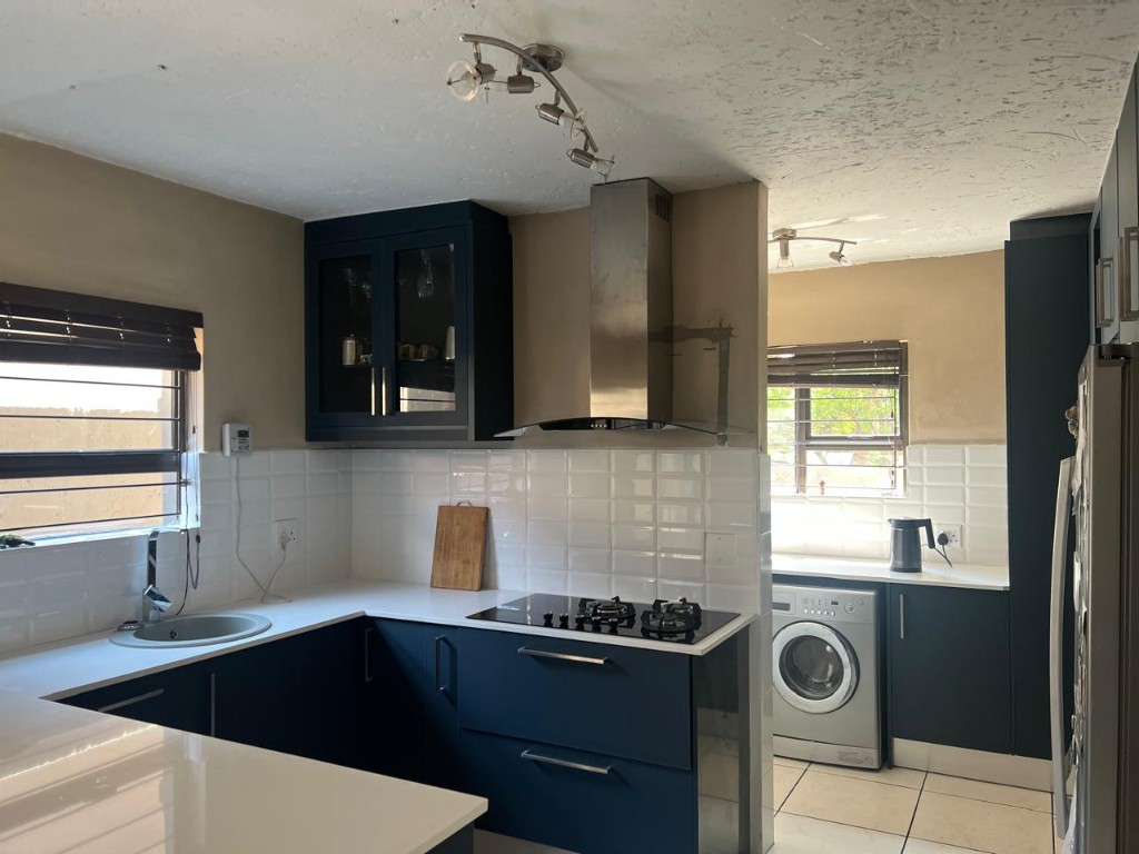 Completed residential kitchen joinery in deep charcoal with white surfaces